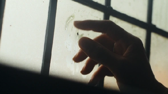 A hand beside a window.