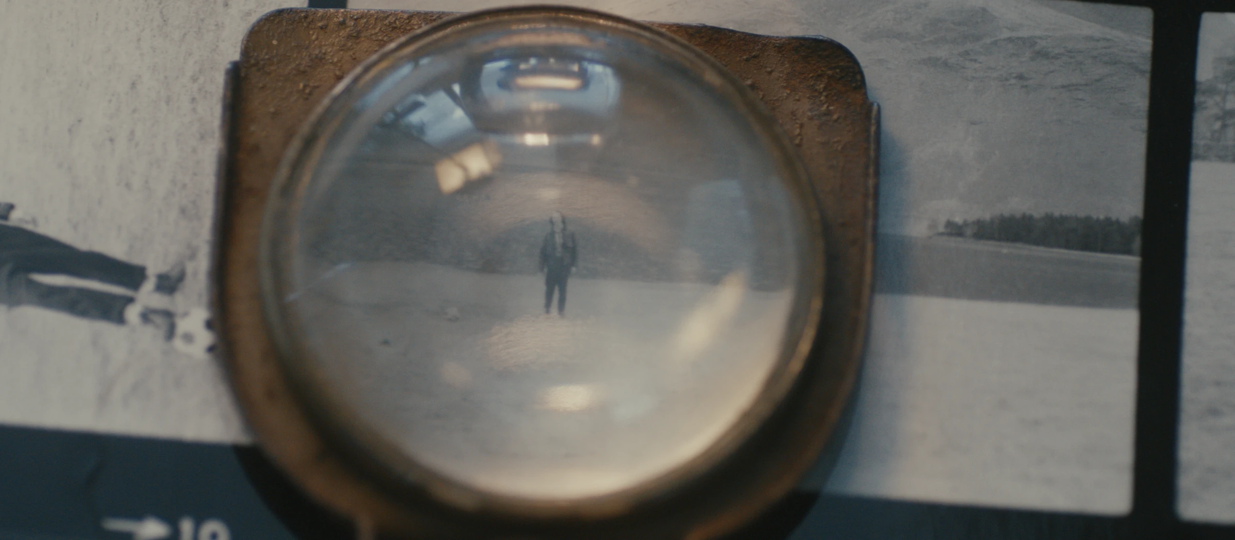 A magnifying glass over an archival photograph.
